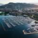 Aerial view of downtown Kelowna, BC, showing Okanagan Lake, City Park, the marina, and surrounding hills in summer